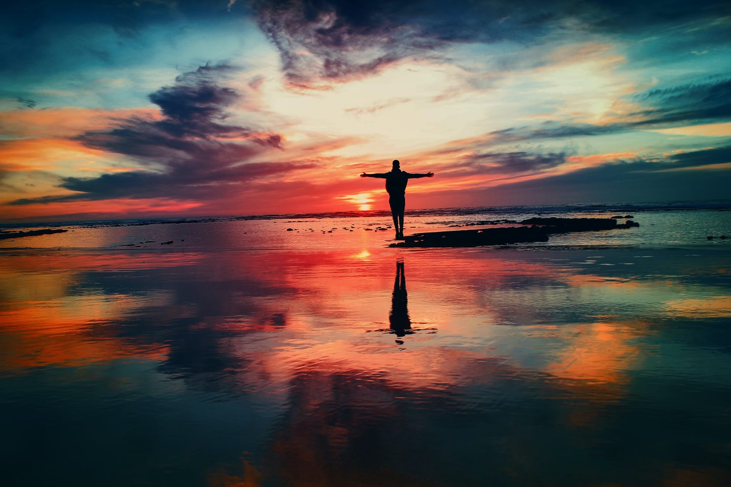 Man with open arms at sea shore